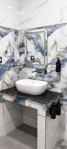 a bathroom with a white sink and a mirror at Hotel Aarambh By Ramayana Grand-Near Ram Mandir Ayodhya in Ayodhya