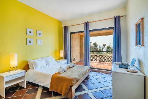 a bedroom with a bed and a desk with a laptop at HI Almada - Pousada de Juventude in Almada