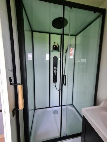 a shower with a glass enclosure in a bathroom at Boerderijcamping KiekeBoe in Maria-Hoop