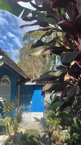 a blue house with a tree in front of it at Pousada no Sana Donna Leda in Sana