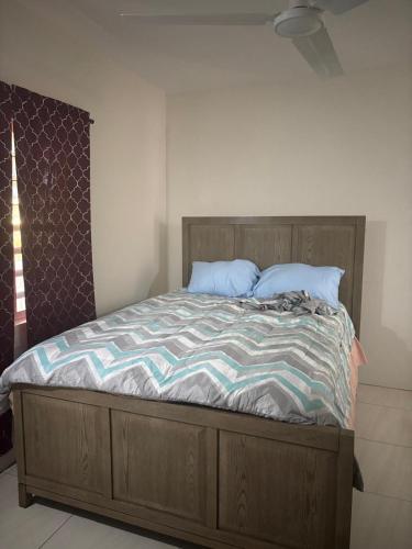 a bedroom with a large bed with blue pillows at Caroline suite in Cliftons
