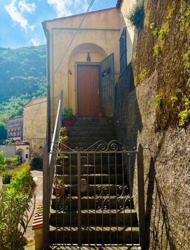 a gate leading up to a building with a red door at L'Oleandro in Maratea