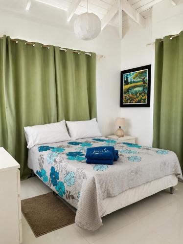 a bedroom with a large bed with green curtains at Vista Marina Residence in Boca Chica