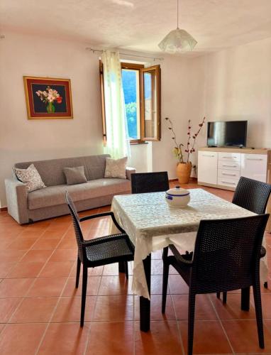 a living room with a table and chairs and a couch at L'Oleandro in Maratea