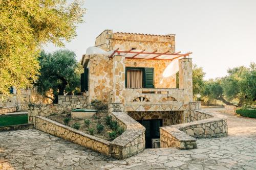 a stone house with a stone staircase in front at oleabungalows in Akrotiri
