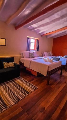 a bedroom with two beds and a window at Loki Cusco in Cusco