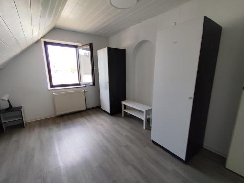 an attic room with a window and a white wall at Reden in Illingen