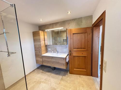 un bagno con lavandino, specchio e doccia di Sonnseit a Sankt Johann in Tirol