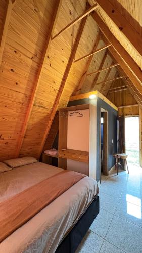 a bedroom with a bed in a wooden ceiling at Chácara Três Chalés in Foz do Iguaçu