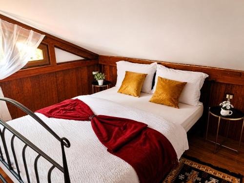ein Schlafzimmer mit einem großen Bett mit weiß-roter Bettwäsche in der Unterkunft La Cascade - Casa de vacanta in Fîntînele