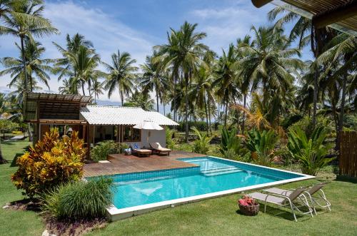 a resort with a swimming pool and palm trees at Hygge Residence - Barra Grande - Península de Maraú in Marau