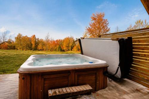 a jacuzzi tub sitting next to a fence at Le Huppe - Spa Ski & River View in Petite-Rivière-Saint-François