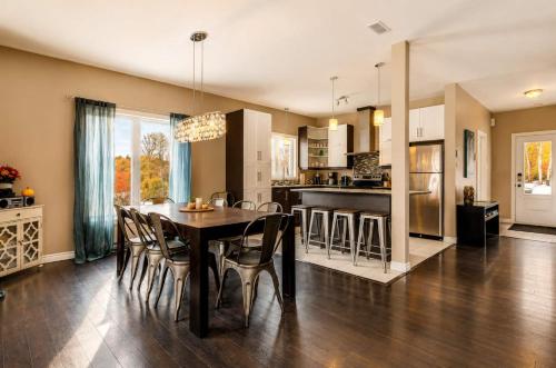 a kitchen and dining room with a table and chairs at Le Huppe - Spa Ski & River View in Petite-Rivière-Saint-François