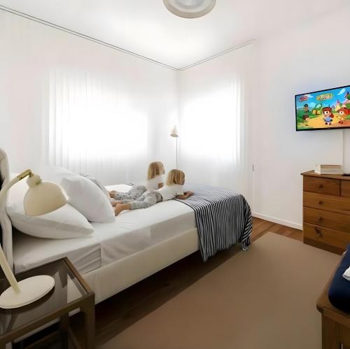 two children sitting on a bed in a bedroom at 30m to Beach - Mindelo Ocean House in Mindelo