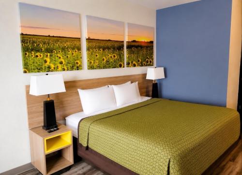 a bedroom with a bed and a field of sunflowers at Days Inn by Wyndham Topeka in Topeka