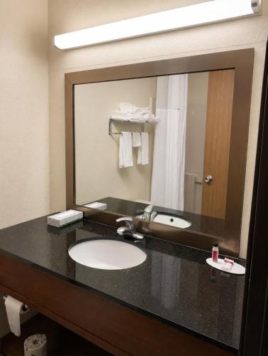 a bathroom with a sink and a large mirror at Days Inn by Wyndham Topeka in Topeka