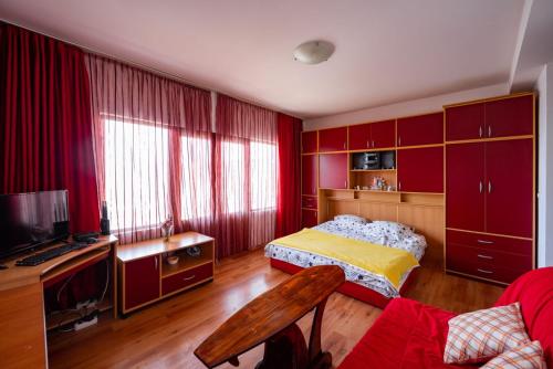 a bedroom with red cabinets and a bed and a couch at Casa Mare & Monti in Budva