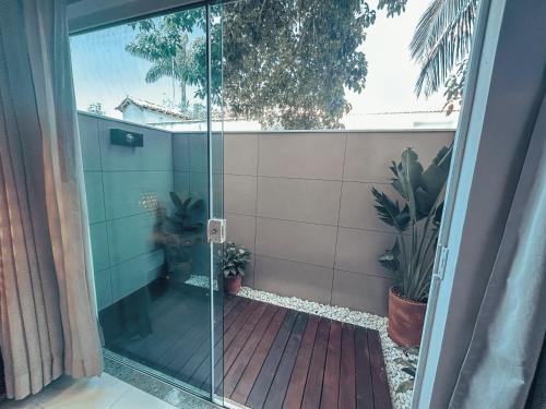 a glass door leading to a balcony with plants at Hotel Paradiso del Sol in Cabo Frio