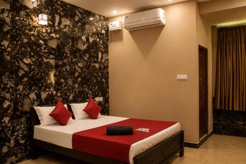 a bedroom with a bed with red pillows at Aquora Pool Stays in Pondicherry