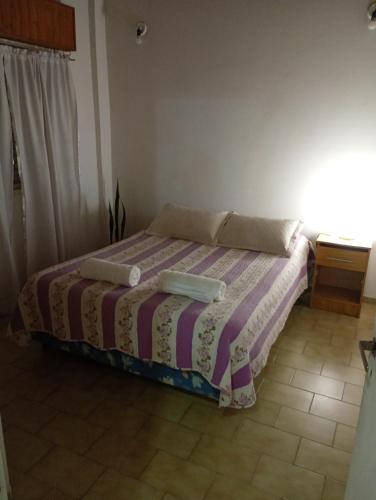 a bedroom with a bed with a striped blanket at Memento Vivere Boutique rooms in Neuquén