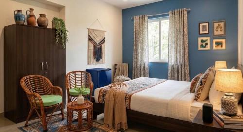a bedroom with a bed and a chair and a window at The Velvet Anchor in Baga