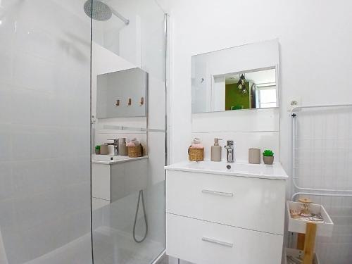a white bathroom with a sink and a shower at Les Glycines Oloron in Oloron-Sainte-Marie