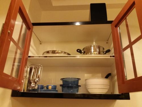 a cupboard with some pots and pans in it at 722 Metropolis Tower Unit 212 in Bacolod