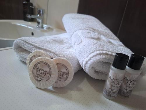 a bathroom with a towel and two products on a sink at Apartments Platz in Mostar