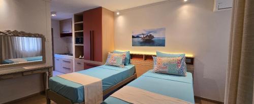 a room with two beds and a tv in it at Elysee Vacances in Trou aux Biches