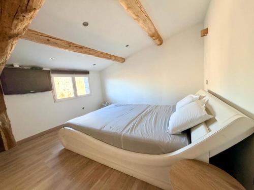 a bedroom with a large bed in a room with wooden ceilings at L'Écrin de Valensole, Charme & terrasse in Valensole