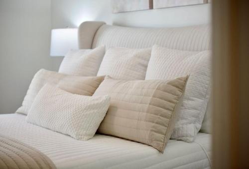 a white bed with four pillows on it at Wlk 2 MSU Fire Pit Pickleball Sleeps 8 in Starkville