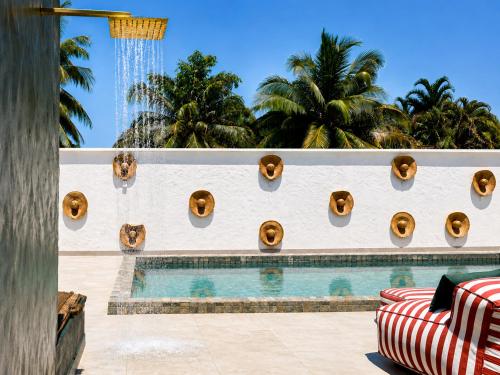 a pool at a resort with palm trees in the background at Raya Beach Studios in Maresias