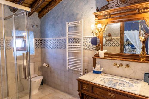 a bathroom with a toilet and a sink and a mirror at Casa Rural El Baluarte - Grupos in Caudilla