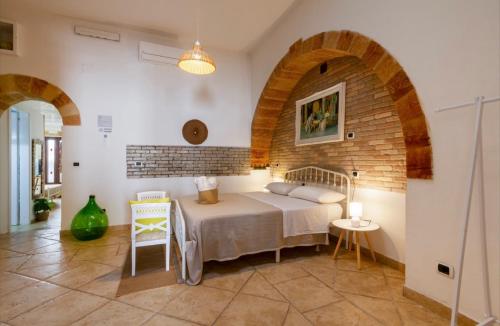 a bedroom with a bed and a brick wall at B&B Corso Garibaldi in Otranto