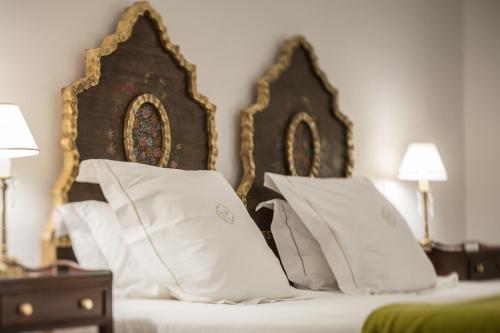 a bed with white pillows and a wooden head board at El Colibri in Santa Catalina