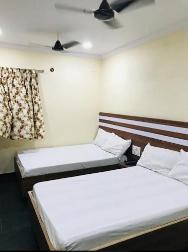 a room with two beds and a window at HoTEL LAALASA in Vijayawāda