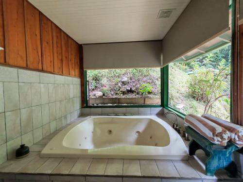 a bath tub in a bathroom with a window at Trogon Lodge in San Gerardo de Dota