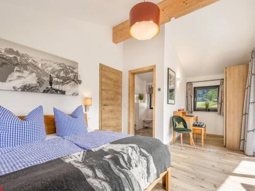 a bedroom with a large bed and a desk at Chalet Alpenzauber mit beheiztem Pool, Inzell in Inzell