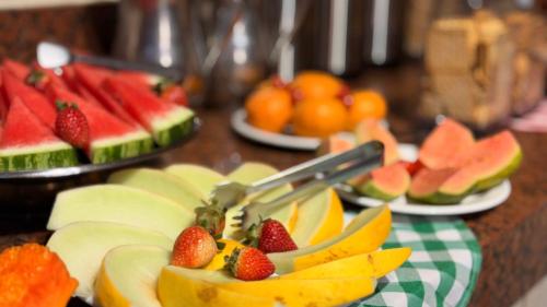 a bunch of fruit on plates on a table at Domus Hotel Cidade Nobre - Ipatinga in Ipatinga