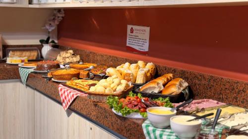 a buffet with many different types of bread and pastries at Domus Hotel Cidade Nobre - Ipatinga in Ipatinga