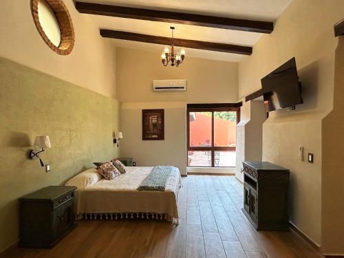 a bedroom with a bed and a television in it at Hacienda Casa Grande, suite esmeralda in Guadalajara