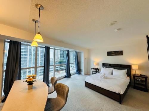 a bedroom with a bed and a table and chairs at Victoria Suites - Downtown in Toronto