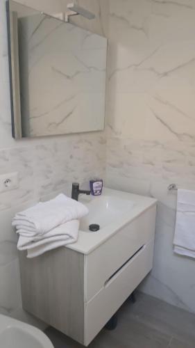 a white bathroom with a sink and a mirror at Appartamento perla in Rome