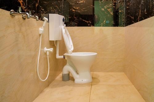 a bathroom with a toilet with a shower at Aquora Pool Stays in Pondicherry