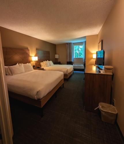 a hotel room with two beds and a flat screen tv at Jonestown Inn in Jonestown