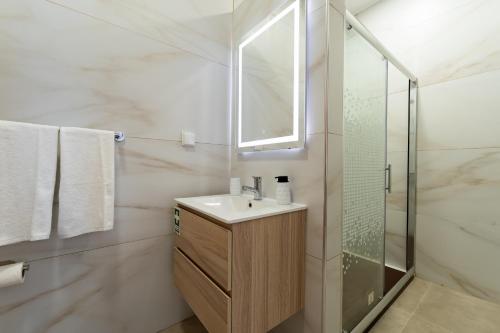 a bathroom with a sink and a glass shower at Casa Turalves - By WeHostMadeira in Porto Santo