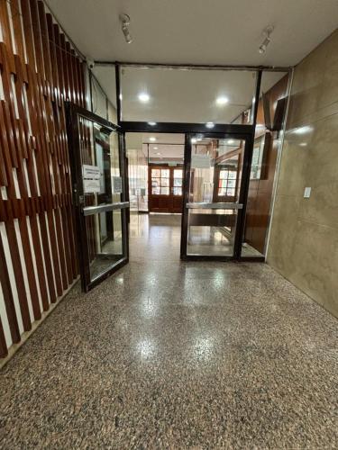 an empty hallway with glass doors in a building at Funcional Lamadrid 62 in Bahía Blanca