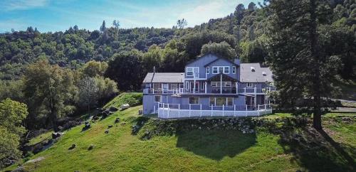 an aerial view of a large blue house on a hill at Mountain Daddies Boutique Bed & Breakfast near Yosemite - Fresh Homemade Breakfast Included in Oakhurst