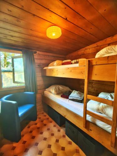 a bedroom with two bunk beds and a blue chair at Beau in Houschthauser