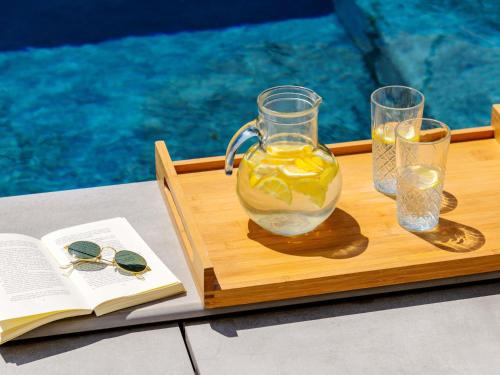 a tray with a jug of lemonade and two glasses at Novotel Parma Centro in Parma